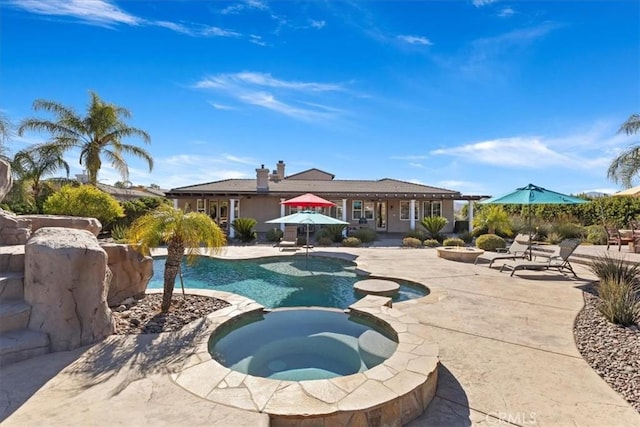 view of pool featuring a patio area and a pool with connected hot tub