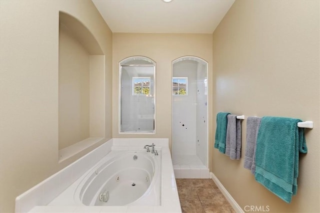 bathroom featuring a jetted tub, baseboards, walk in shower, and tile patterned floors