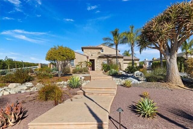 view of front facade featuring stucco siding and stone siding