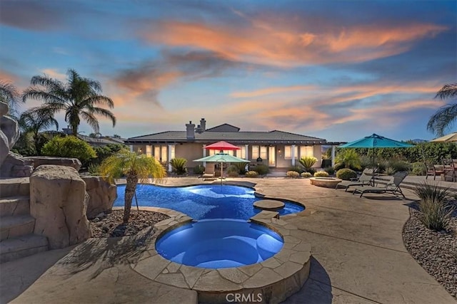 view of pool with a pool with connected hot tub and a patio area