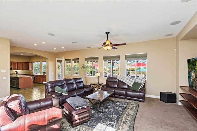 living room with baseboards, recessed lighting, arched walkways, ceiling fan, and dark colored carpet