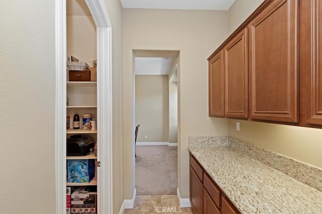 interior space featuring baseboards and light colored carpet