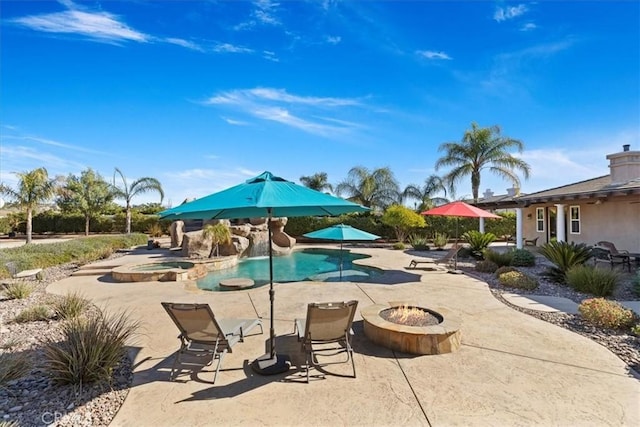 view of pool with a fire pit, a patio, and a pool with connected hot tub