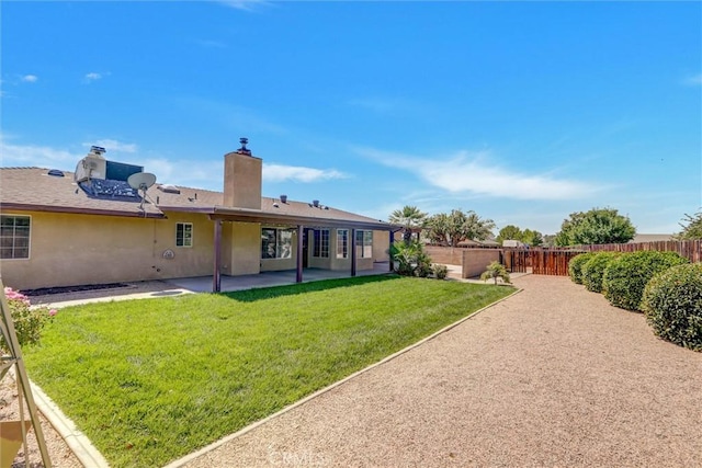 back of house with a lawn and a patio area