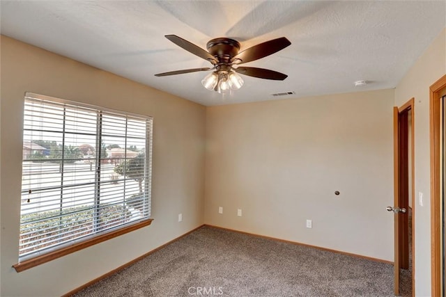 carpeted spare room featuring ceiling fan