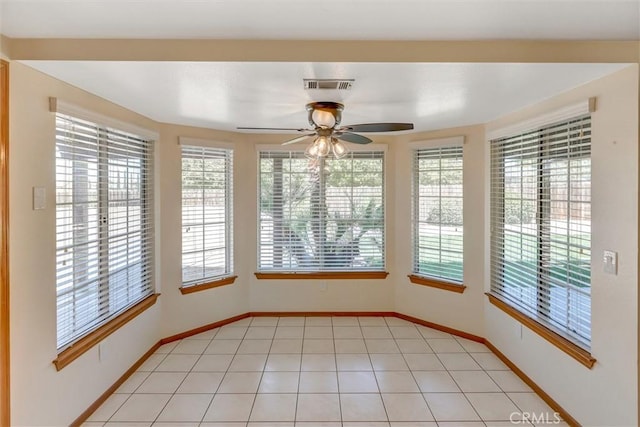 tiled empty room with plenty of natural light and ceiling fan