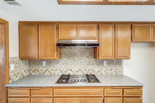 kitchen with stainless steel gas cooktop and tasteful backsplash