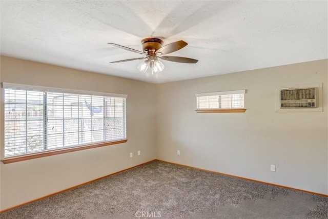 carpeted spare room featuring a wall mounted AC and ceiling fan