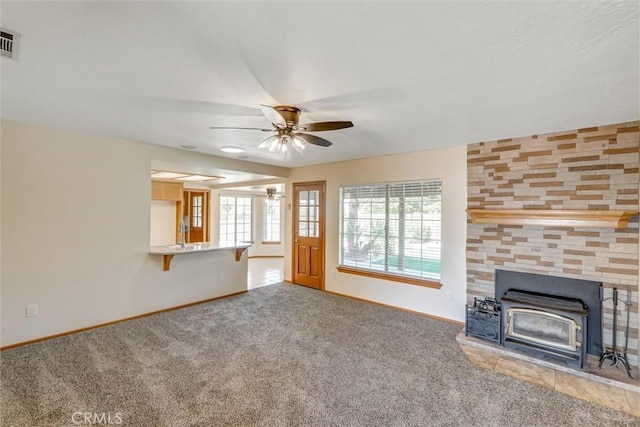 unfurnished living room with carpet flooring, ceiling fan, and a healthy amount of sunlight