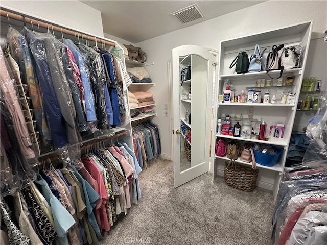 walk in closet with carpet flooring