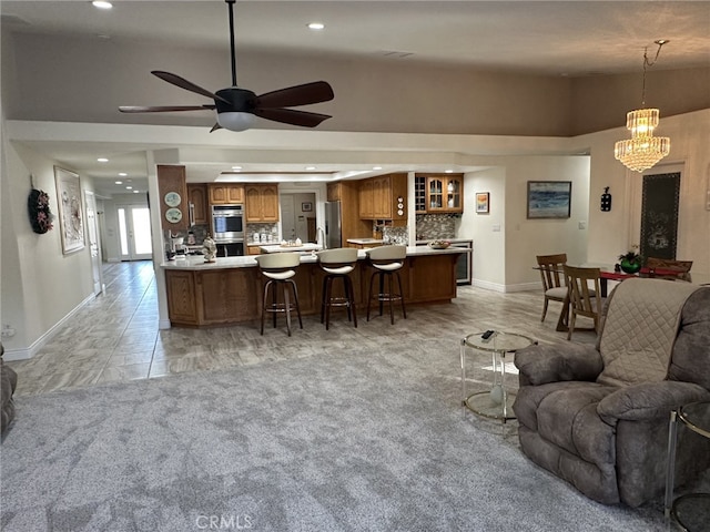 living room with ceiling fan with notable chandelier, light colored carpet, lofted ceiling, and indoor bar