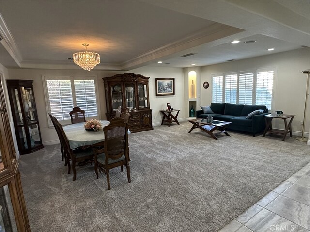 dining area with an inviting chandelier, carpet floors, ornamental molding, and a tray ceiling