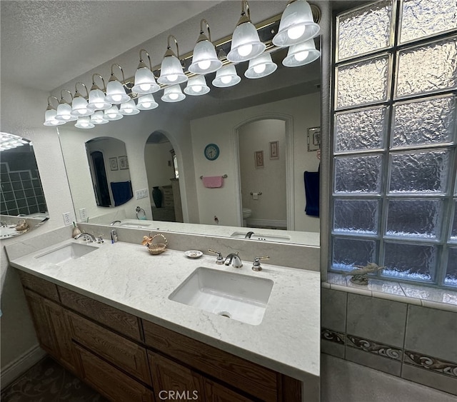 bathroom featuring vanity, a textured ceiling, and toilet