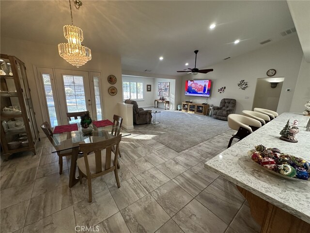 dining space with ceiling fan with notable chandelier and lofted ceiling