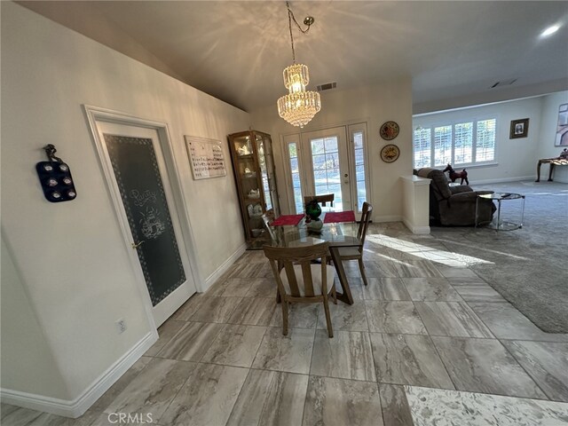 carpeted dining space with lofted ceiling and an inviting chandelier