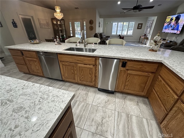 kitchen with pendant lighting, sink, ceiling fan, light stone counters, and stainless steel dishwasher