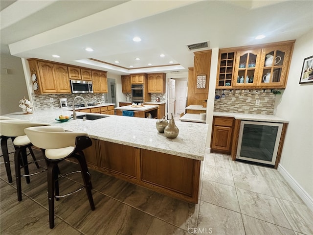16232 Ridge View Dr, Apple Valley, CA 92307 - kitchen featuring beverage cooler, stainless steel appliances, a raised ceiling, tasteful backsplash, and recessed lighting