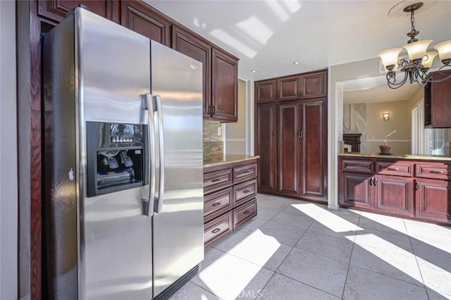 kitchen featuring stainless steel fridge, light tile patterned flooring, a chandelier, and hanging light fixtures