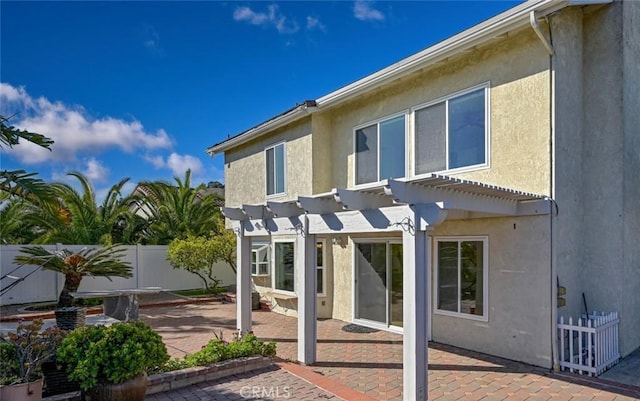 rear view of property with a patio area and a pergola