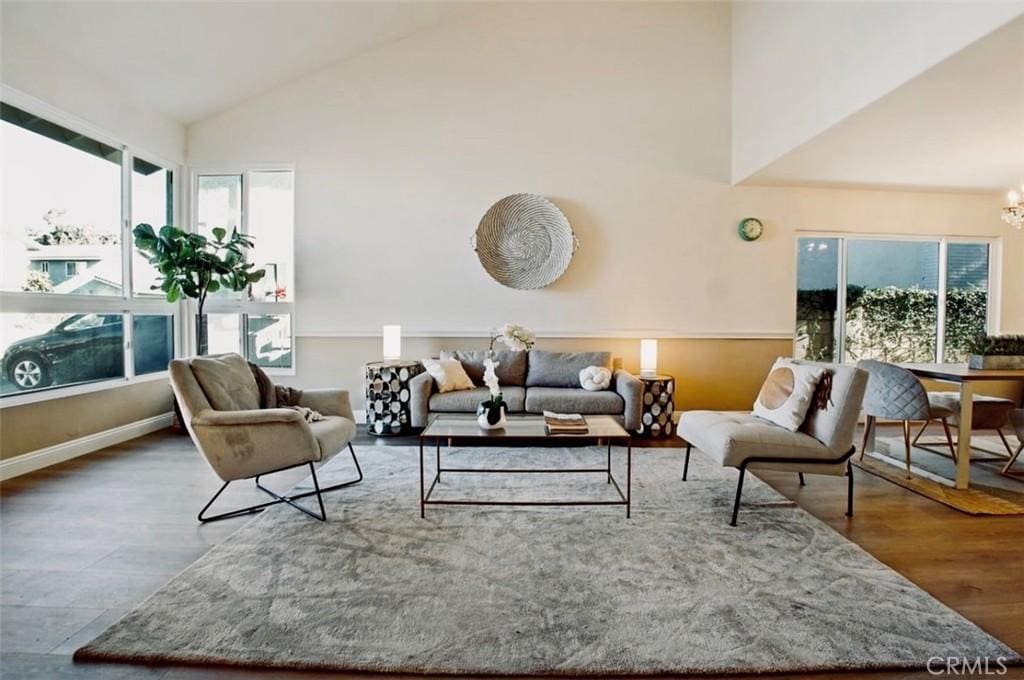 living room featuring lofted ceiling, a chandelier, and wood-type flooring