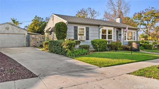 view of front of house featuring a front lawn, an outdoor structure, and a garage