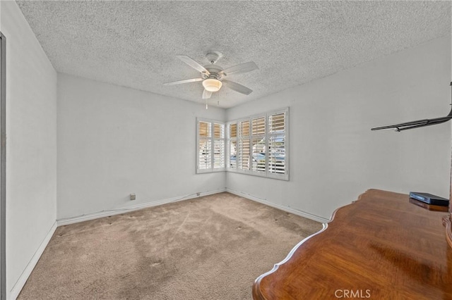 carpeted empty room featuring ceiling fan and a textured ceiling