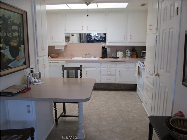 kitchen featuring a breakfast bar, sink, white cabinets, and white appliances