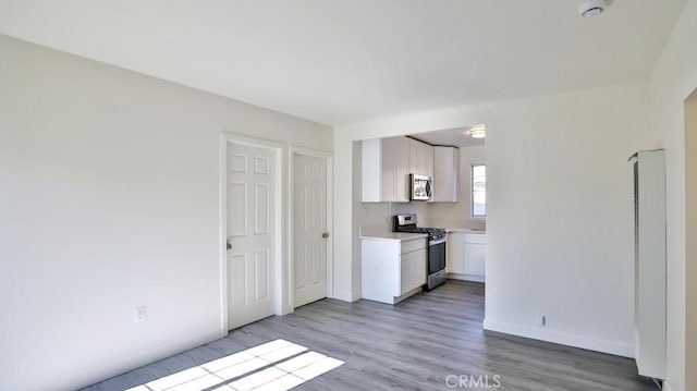 kitchen featuring light hardwood / wood-style flooring, stainless steel appliances, and white cabinetry