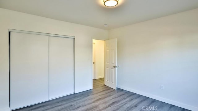 unfurnished bedroom with a closet and hardwood / wood-style floors