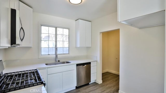 kitchen featuring stainless steel appliances, white cabinets, hardwood / wood-style flooring, and sink