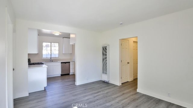 kitchen with white cabinets, light hardwood / wood-style flooring, dishwasher, and range