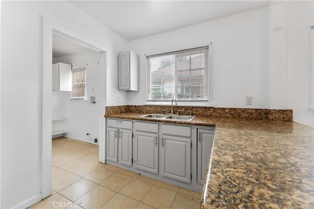 kitchen with light tile patterned floors, sink, and gray cabinets