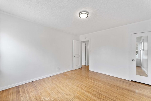 empty room featuring a textured ceiling and light hardwood / wood-style floors