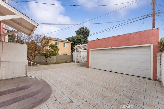 view of patio with an outbuilding and a garage