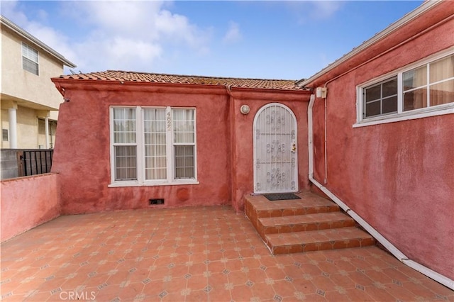 view of exterior entry with a patio