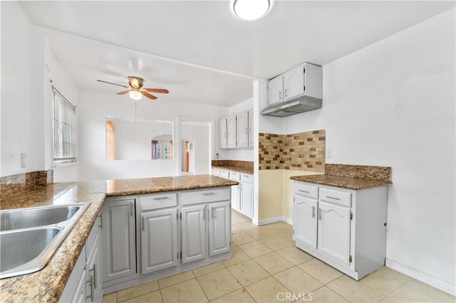 kitchen featuring white cabinetry, kitchen peninsula, ceiling fan, tasteful backsplash, and sink