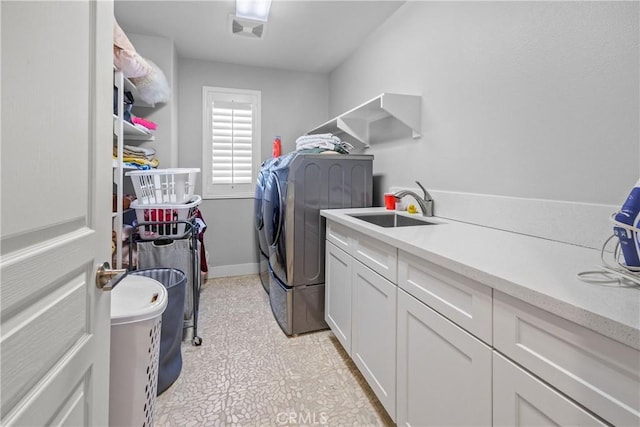 laundry area featuring cabinets, independent washer and dryer, and sink