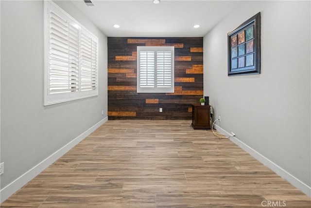 interior space with hardwood / wood-style floors and wooden walls