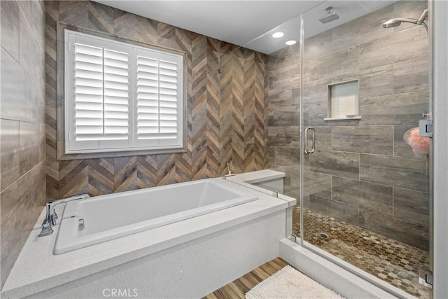 bathroom featuring shower with separate bathtub