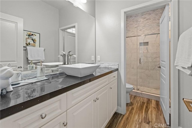 bathroom featuring vanity, hardwood / wood-style flooring, toilet, and an enclosed shower