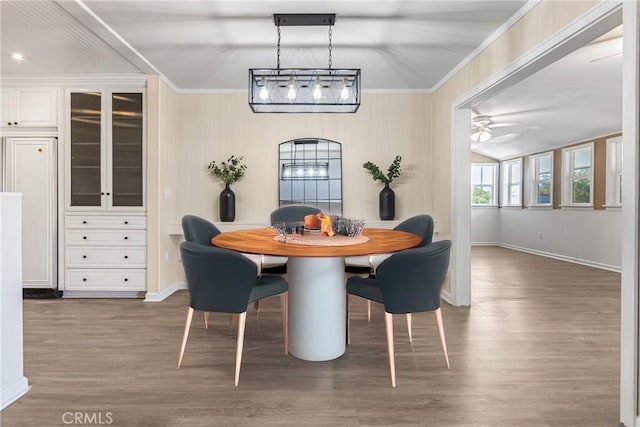 dining space featuring ceiling fan, crown molding, and dark wood-type flooring