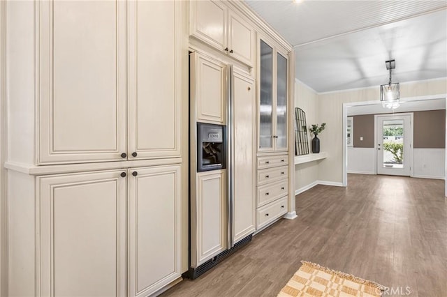 kitchen featuring pendant lighting, light hardwood / wood-style flooring, paneled refrigerator, and cream cabinetry