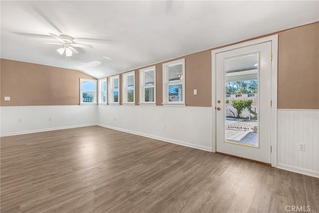 spare room with lofted ceiling, ceiling fan, a healthy amount of sunlight, and dark wood-type flooring