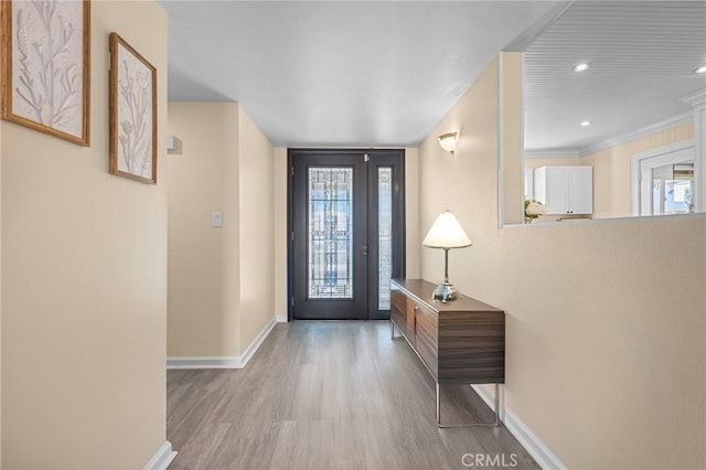 entryway featuring crown molding and light hardwood / wood-style flooring