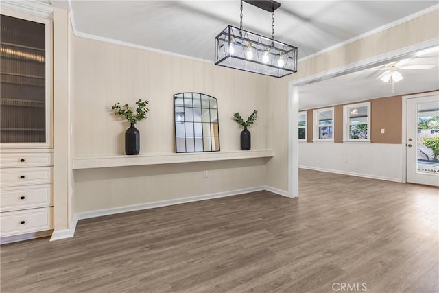 interior space with dark hardwood / wood-style flooring, ceiling fan, and crown molding