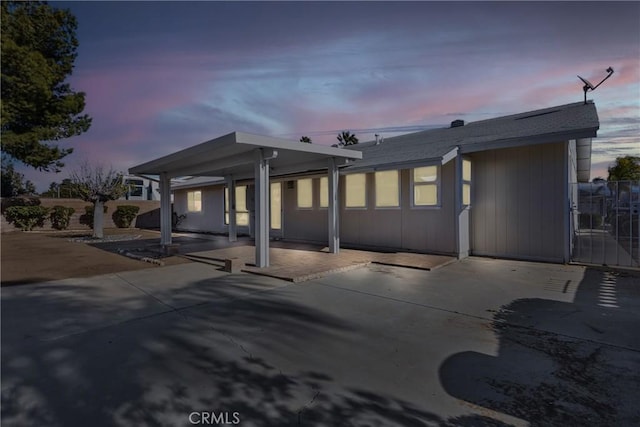 back house at dusk featuring a patio