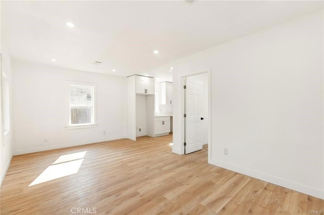 empty room with light hardwood / wood-style flooring