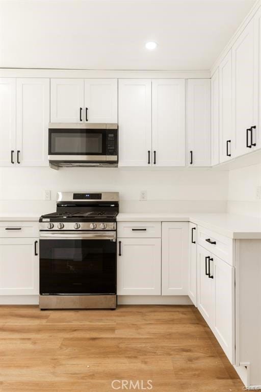 kitchen featuring white cabinets, stainless steel appliances, and light hardwood / wood-style flooring