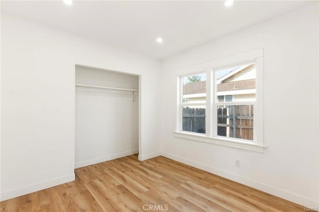 unfurnished bedroom featuring light hardwood / wood-style floors and a closet