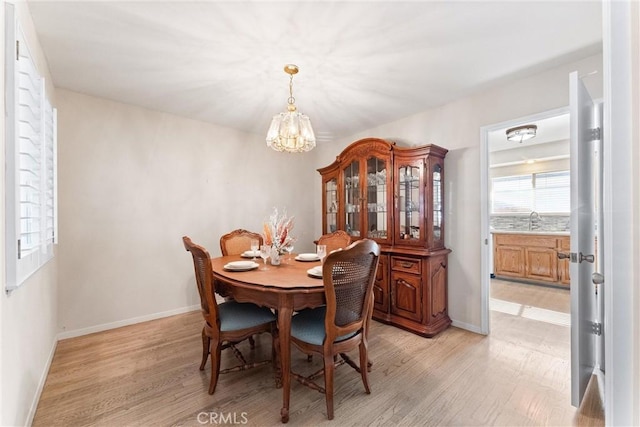 dining area with a chandelier, light hardwood / wood-style flooring, and sink